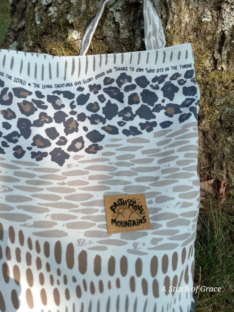 A tote bag made from WayMaker Fabrics with a faith-based "Everything that has Breath" print in leopard and dotted patterns.