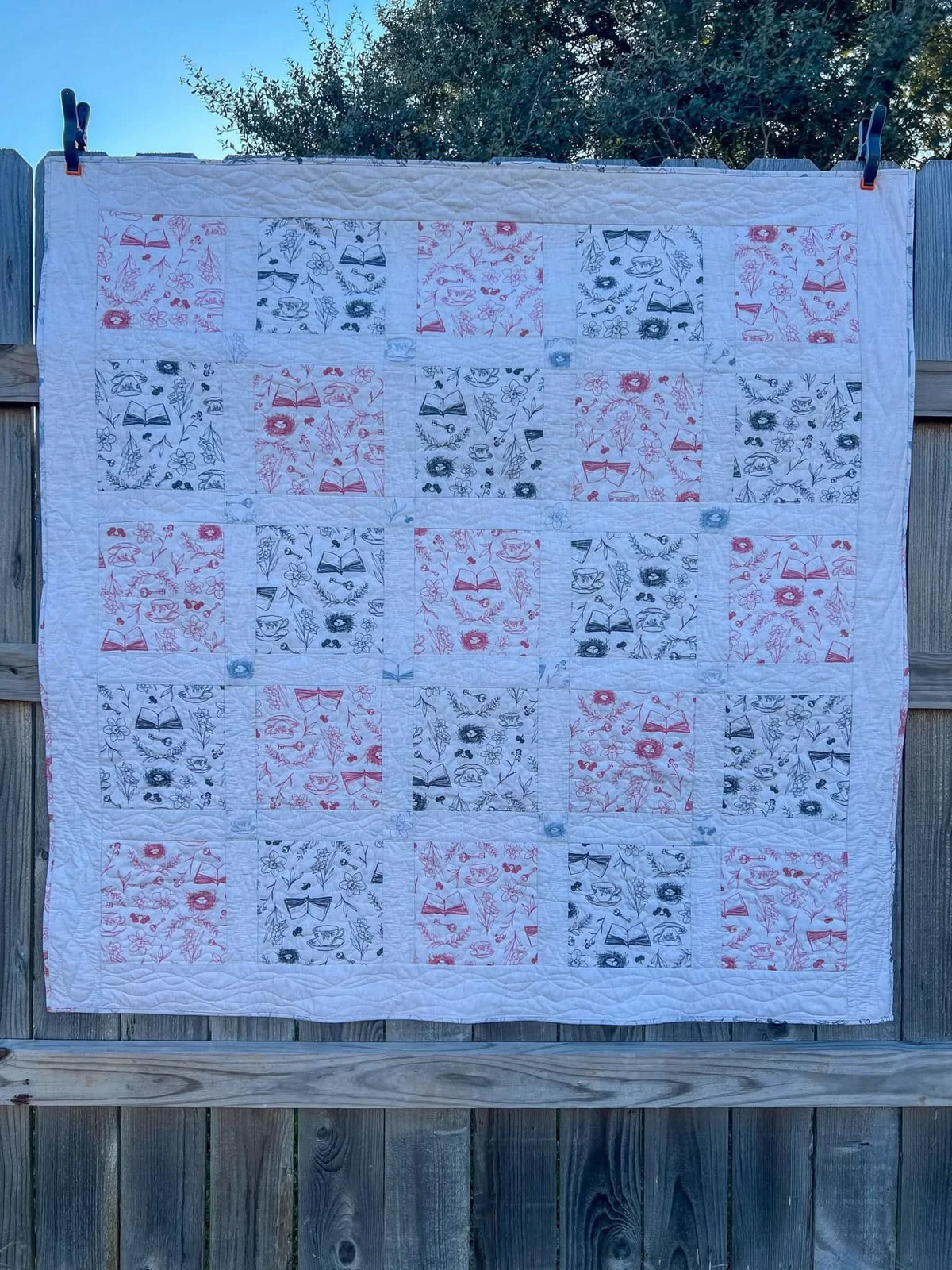 Red tea and toile faith-based print fabric in pink and black on white background.