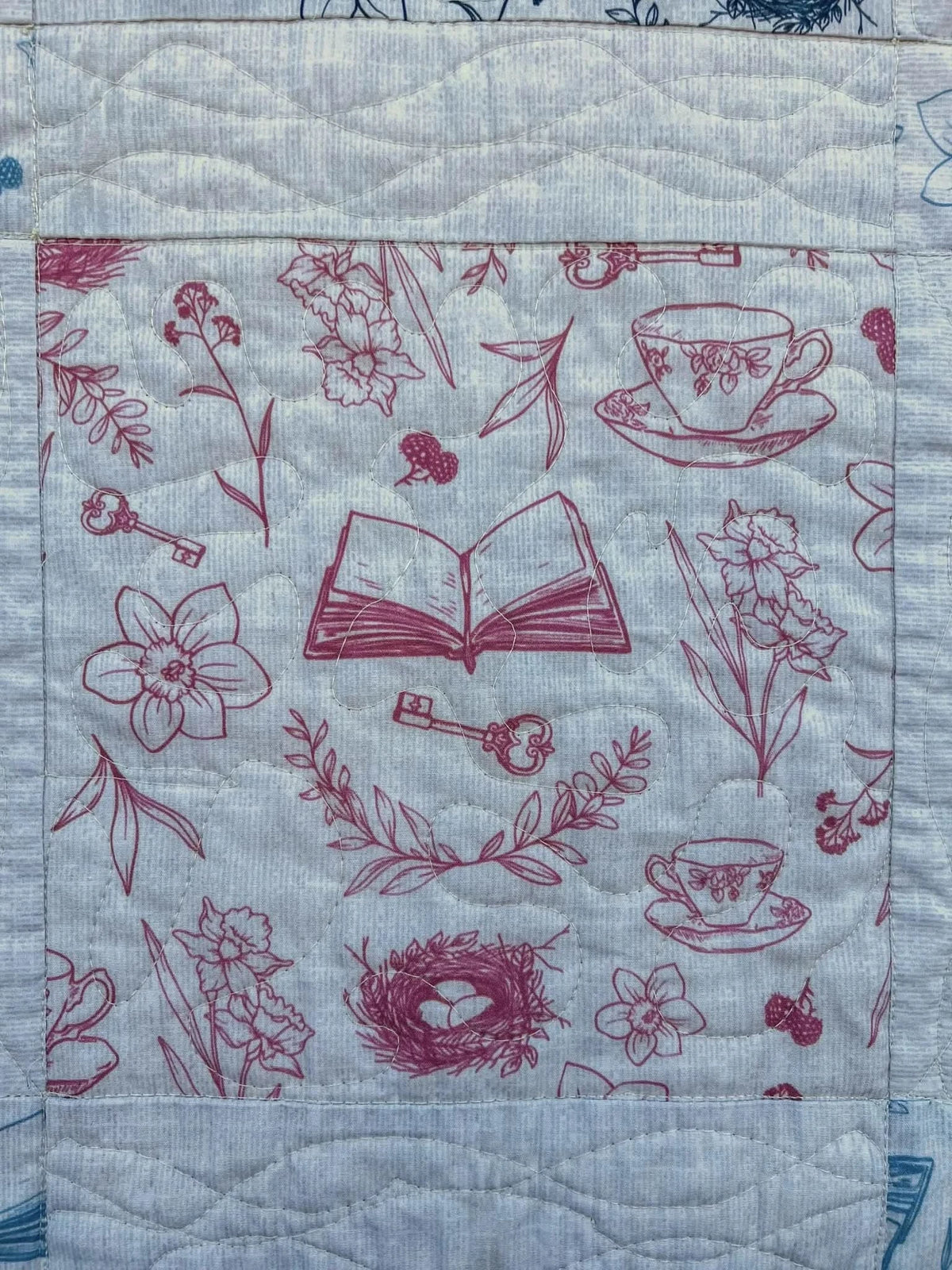Red tea and toile faith-based print fabric with flowers, books, teacups, and keys.