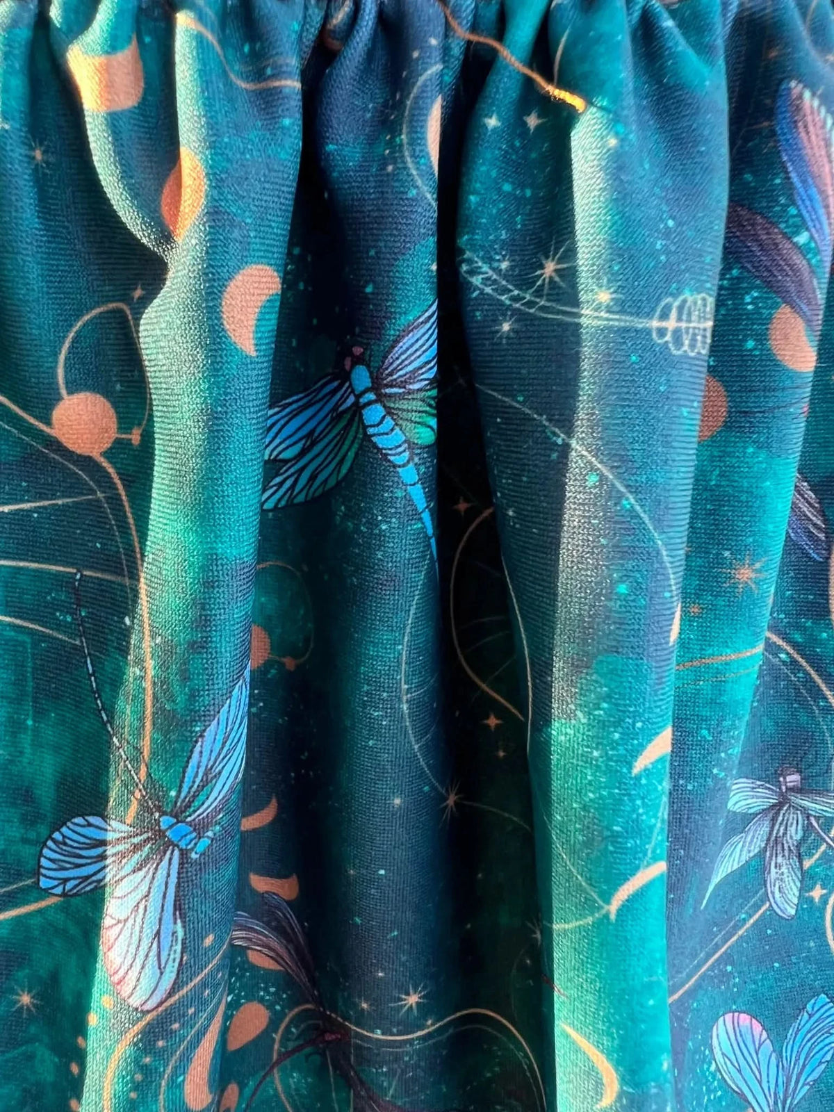 Celestial dragonflies fantasy print fabric in teal with stars and moons.