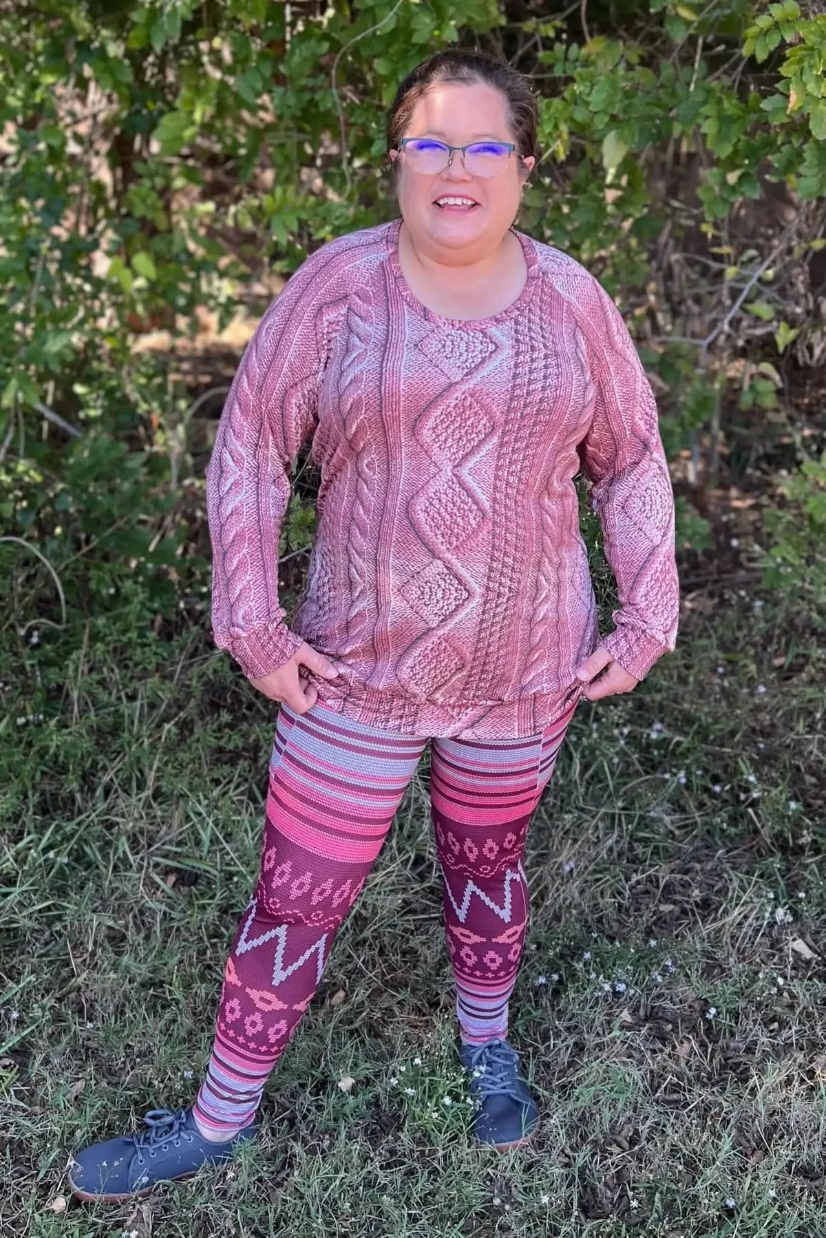 Woman modeling pink abstract Glacier Mirage fabric sweater and pants outdoors.