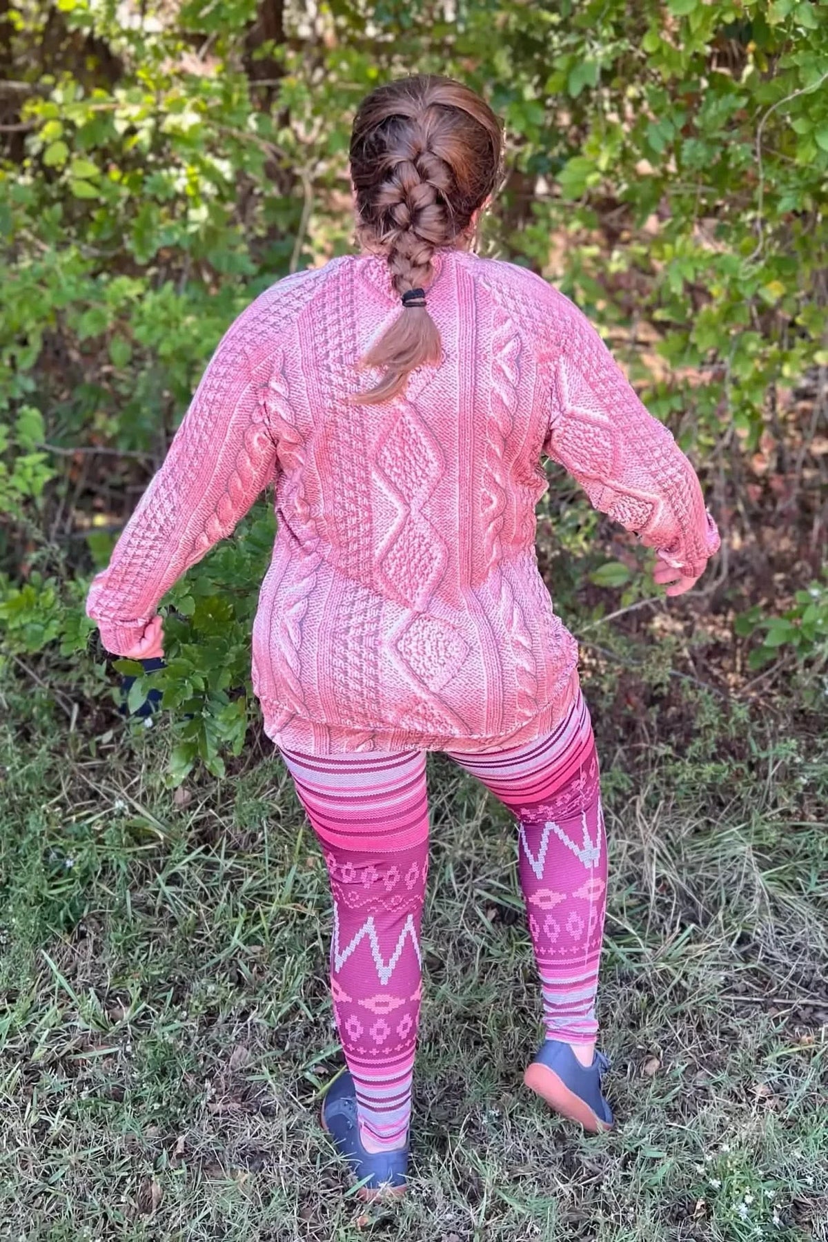 Pink textured knit fabric with rose cable pattern, shown as a woman's sweater and leggings in outdoor setting.