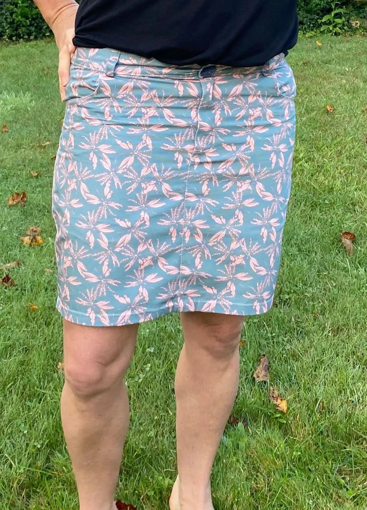 Blush hollow floral print fabric with light blue leaves on pink background.