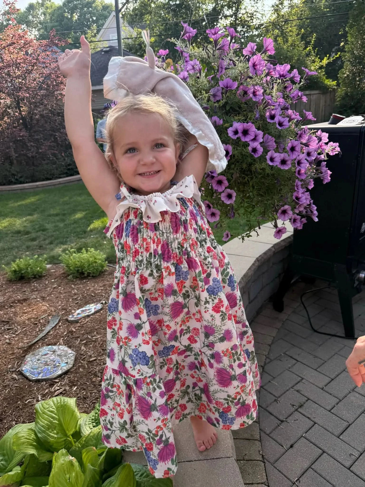 Floral print fabric with thistle field pattern in purple, pink, and white on cream background.