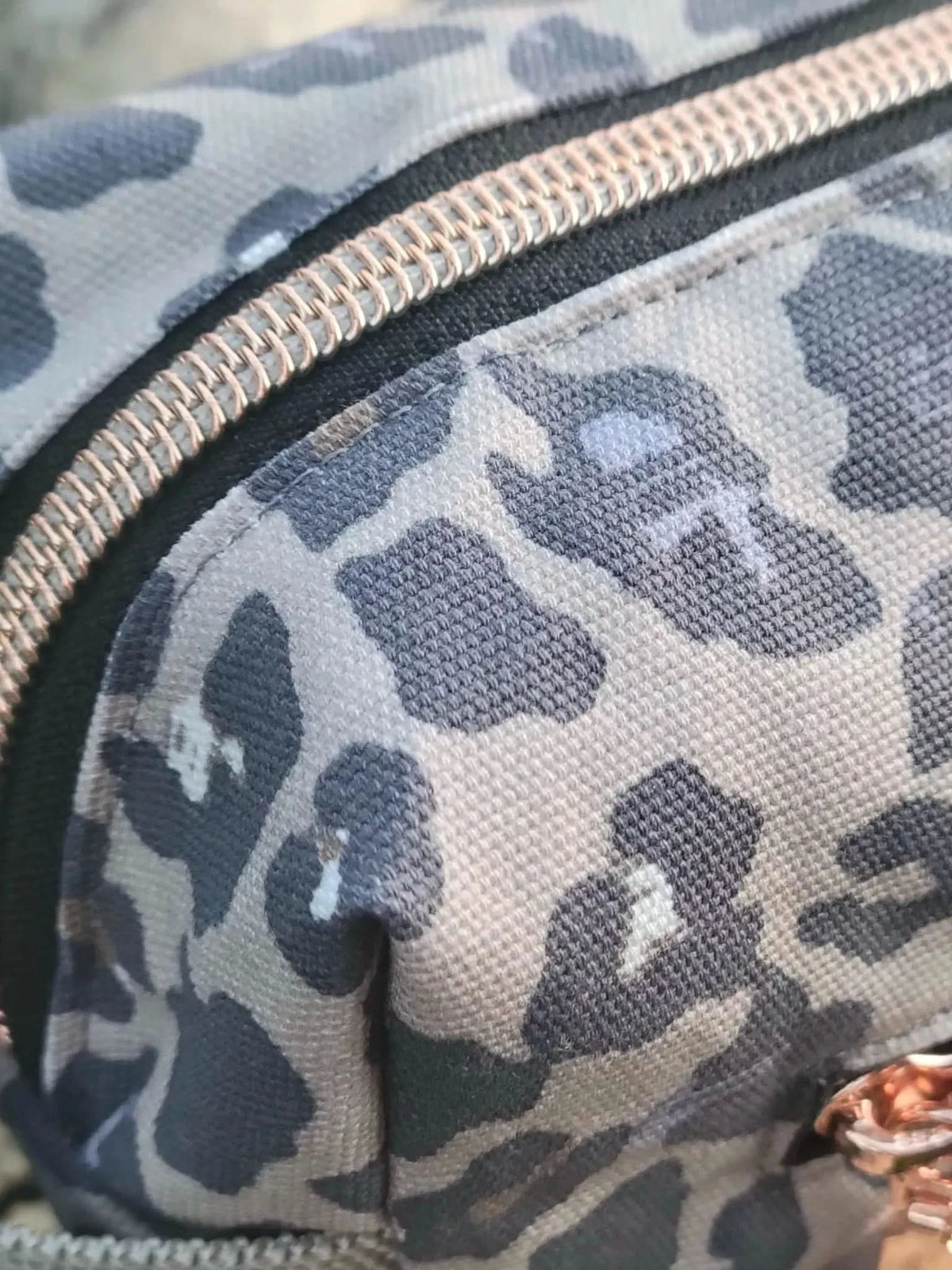 Autumn leopard print fabric with gray and black spots on a neutral background.