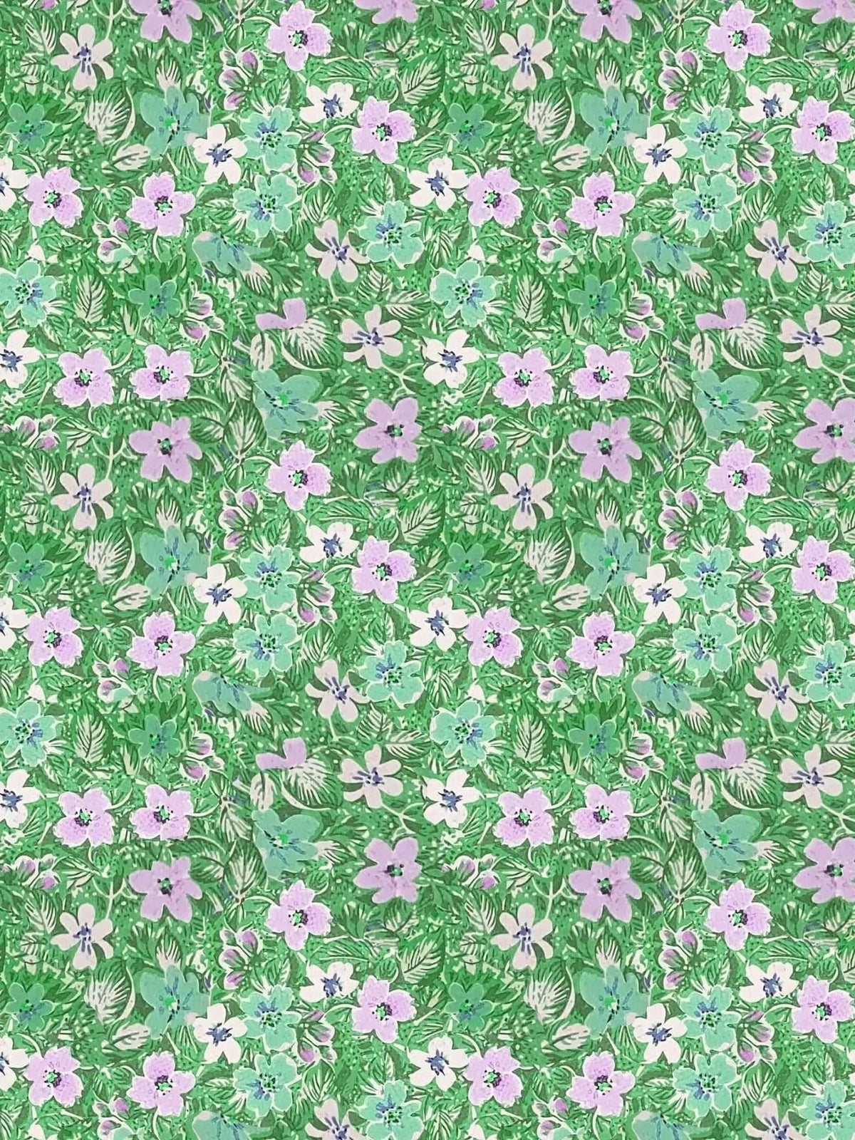 Green floral print fabric featuring leaves and flowers on a green background.