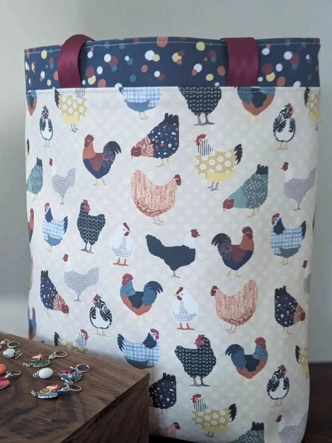 Patchwork fabric with colorful printed chickens in various poses on a light background.