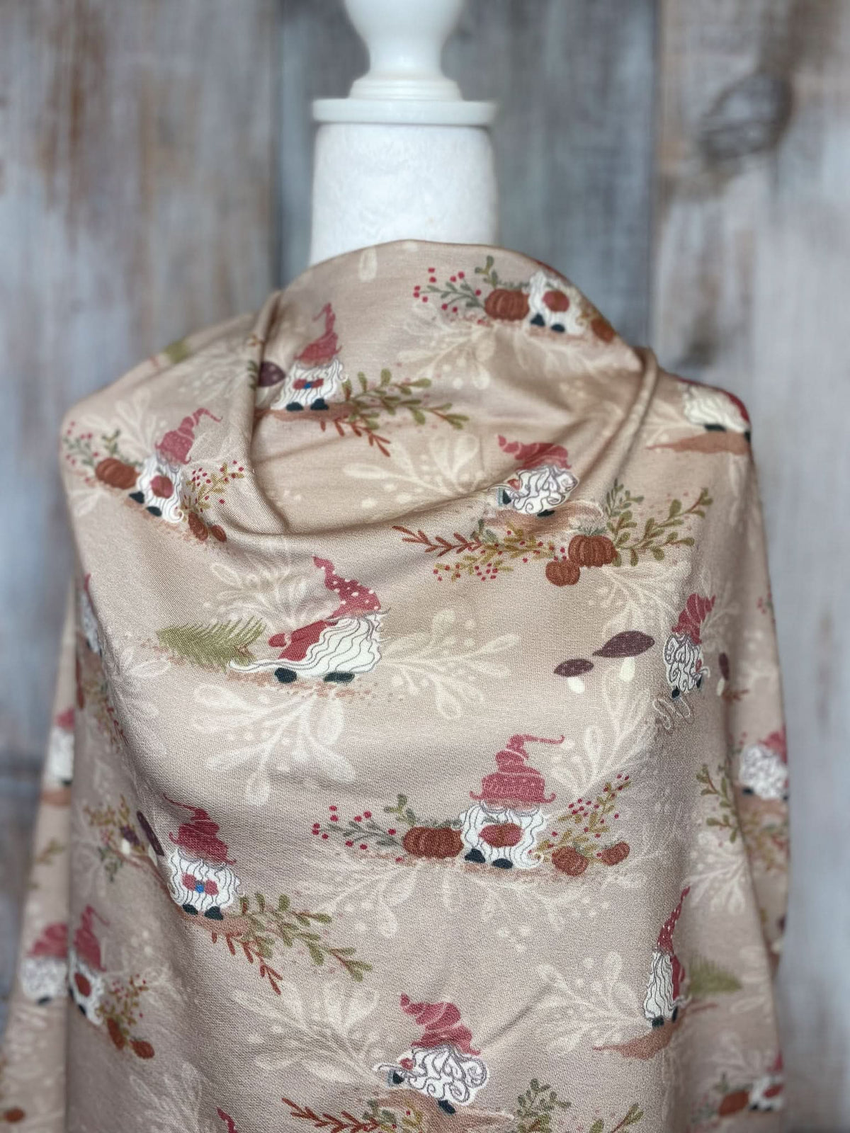 Tan fabric with a gnome toile pattern draped over a mannequin.