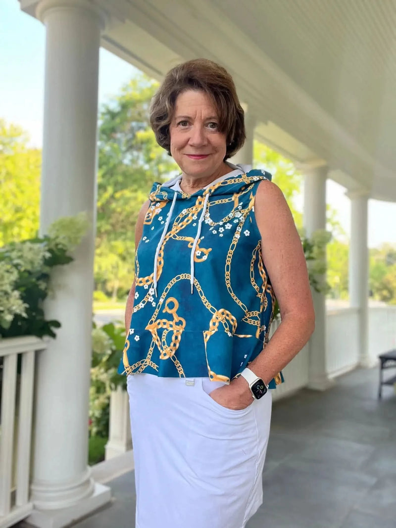 Teal floral chain print fabric with gold chain motifs on a sleeveless hooded top.