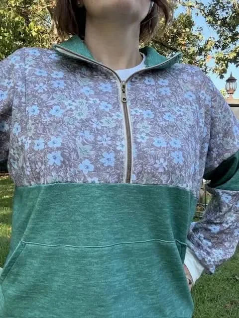 Grass green heather fabric with subtle floral pattern in a sewn hoodie.