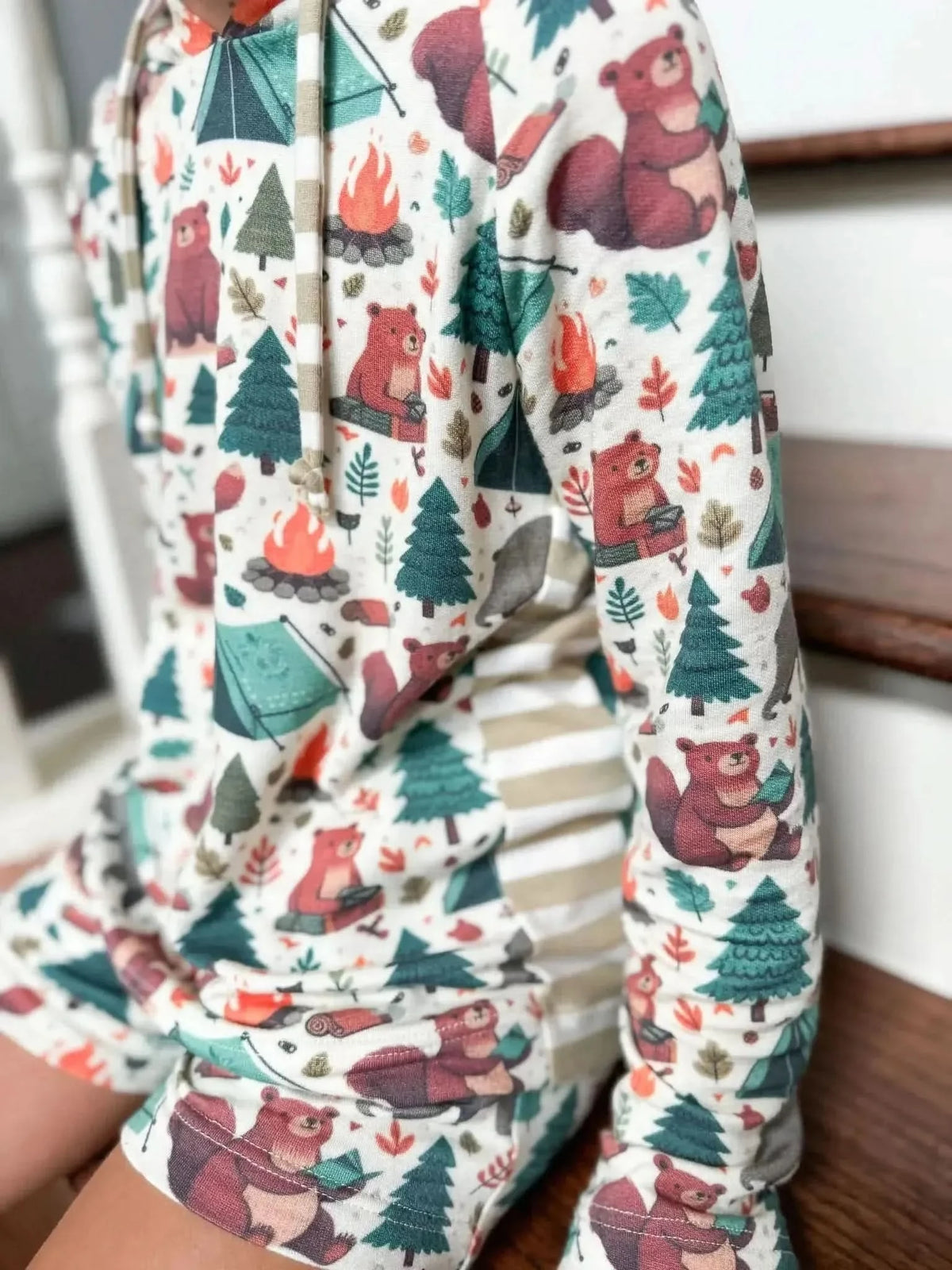 Fabric with camping bears, tents, trees, and campfires in a woodland theme.