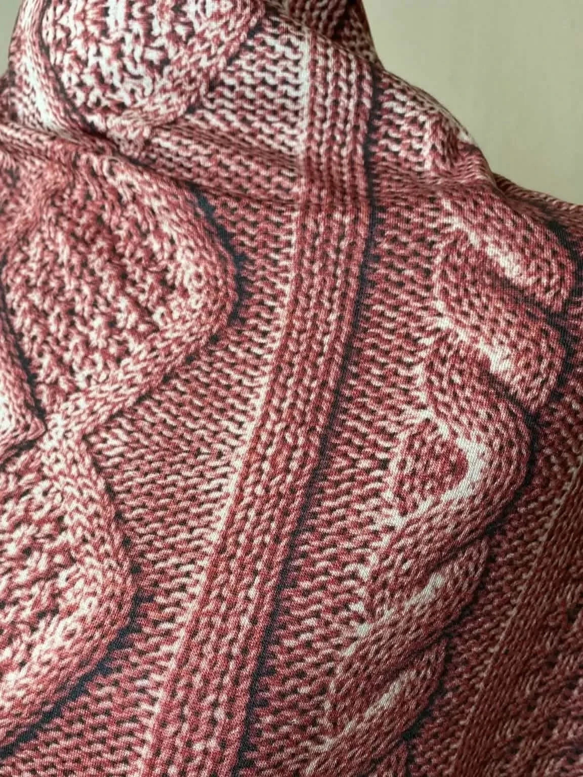 Pink rose cable knit fabric with textured cable patterns.