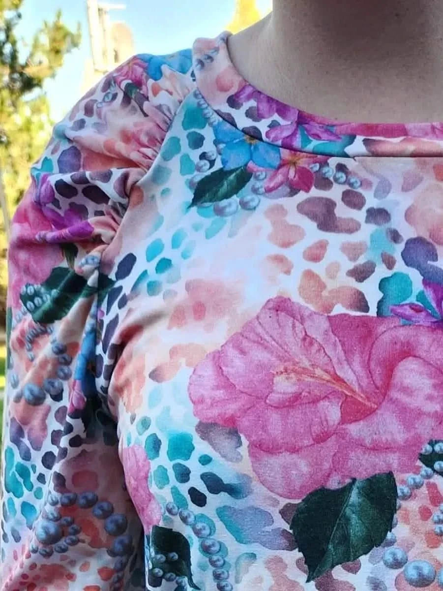 Vibrant tropical fabric with wild hibiscus floral print in pink, blue, and green.