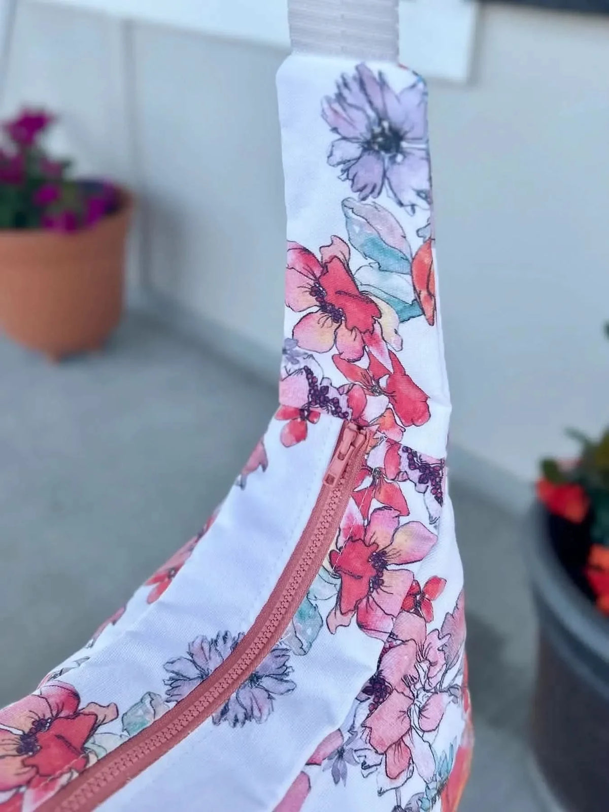 White fabric with colorful floral print, featuring purple, pink, and red flowers.