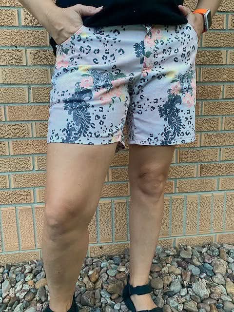 A person wears shorts with a leopard print and floral lace pattern.