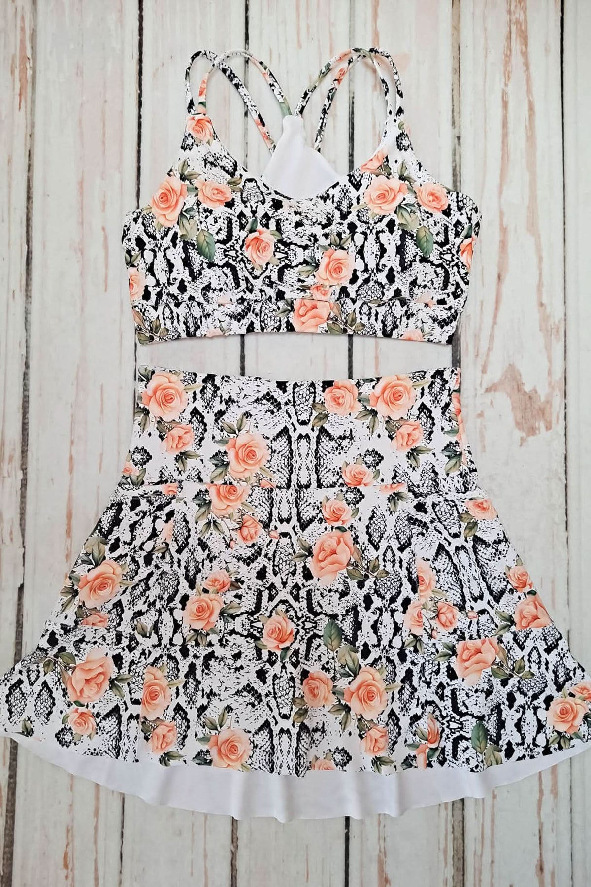 A two-piece outfit with a floral and snake print on a white background.