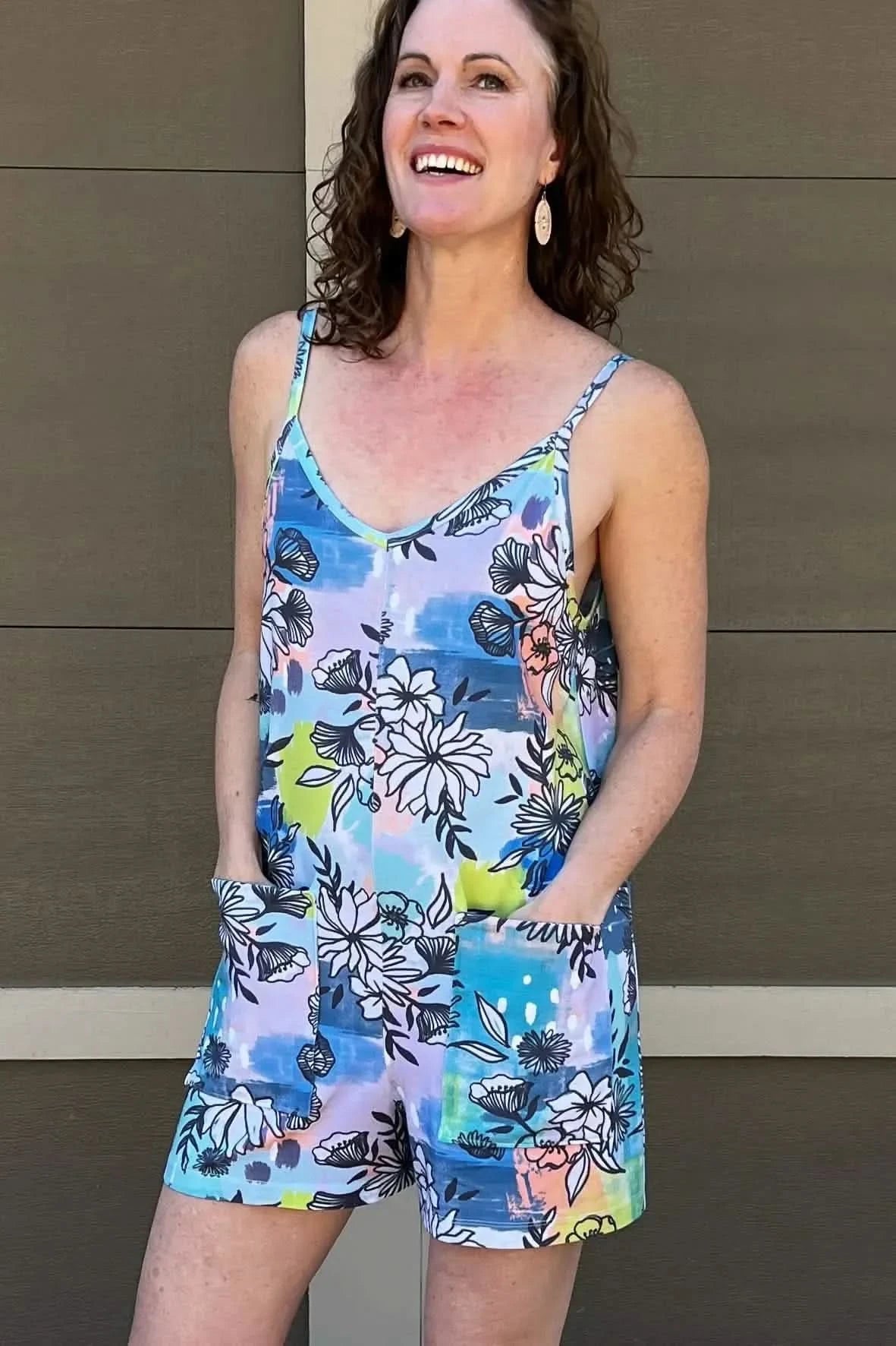 Blue graffiti floral print fabric with abstract purple, pink, and green flowers.