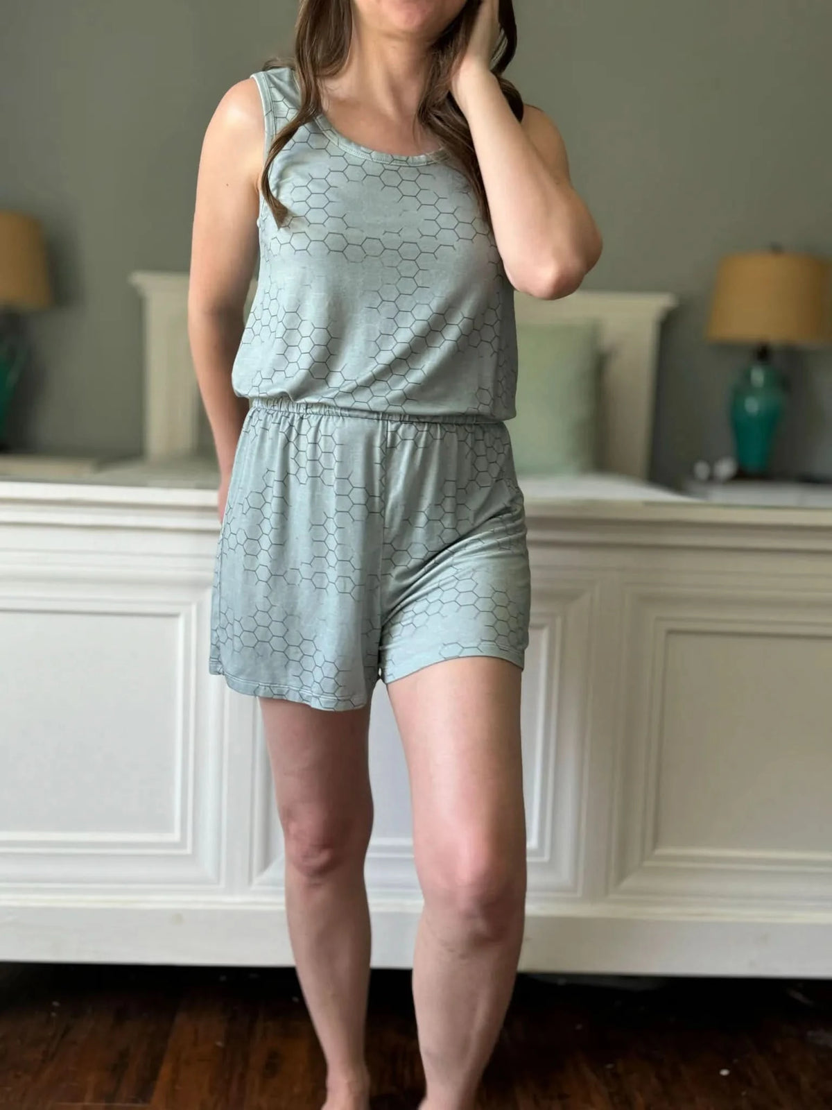 Light green honeycomb geometric print fabric swatch on a model wearing a tank top and shorts.
