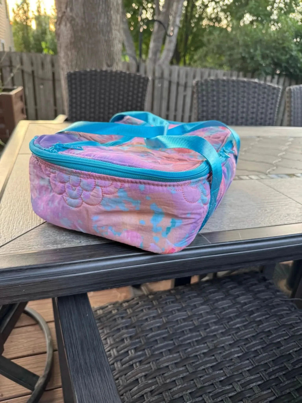 A quilted bag made from Glass Flowers Fabric in purple, pink, and blue.