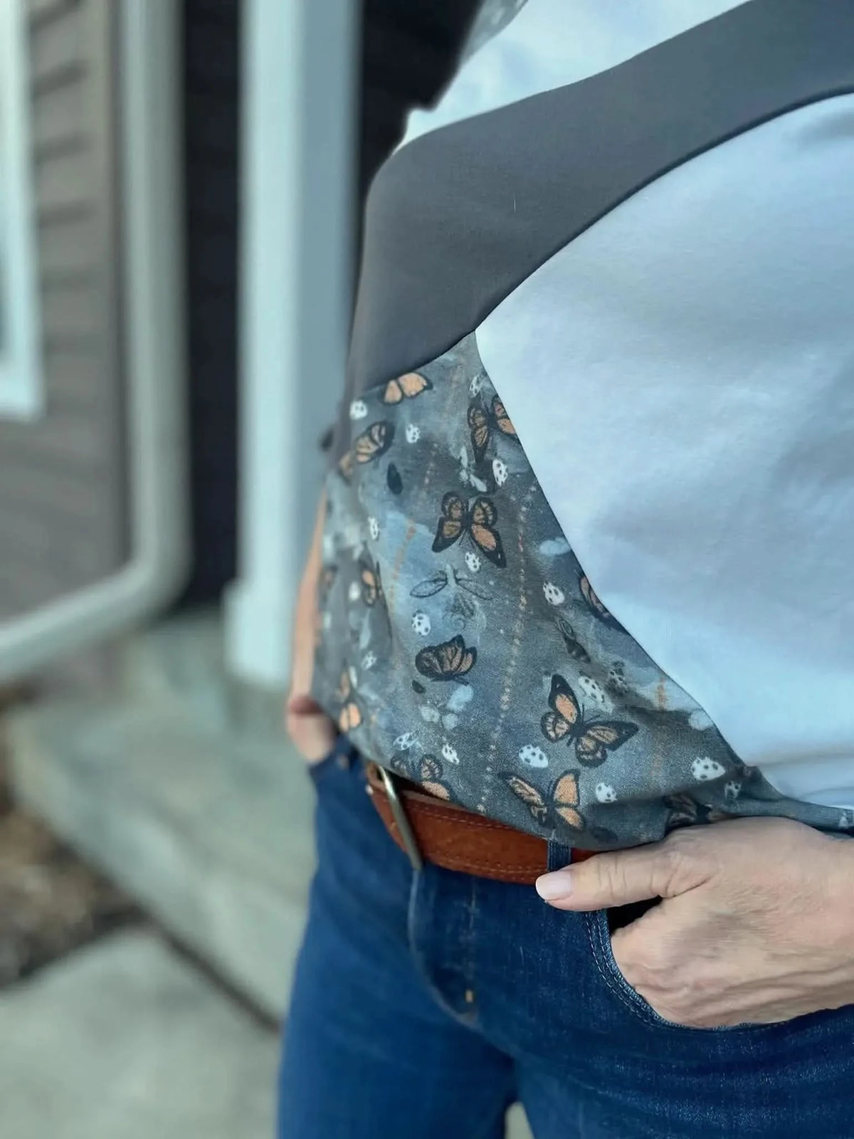 Gray fabric with a subtle monarch butterfly print pattern.