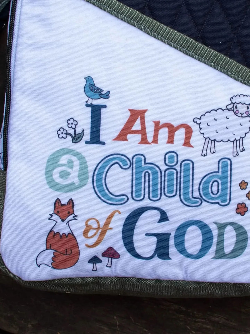 White fabric panel with "I Am a Child of God" text, fox, sheep, bird, flowers, and mushrooms.