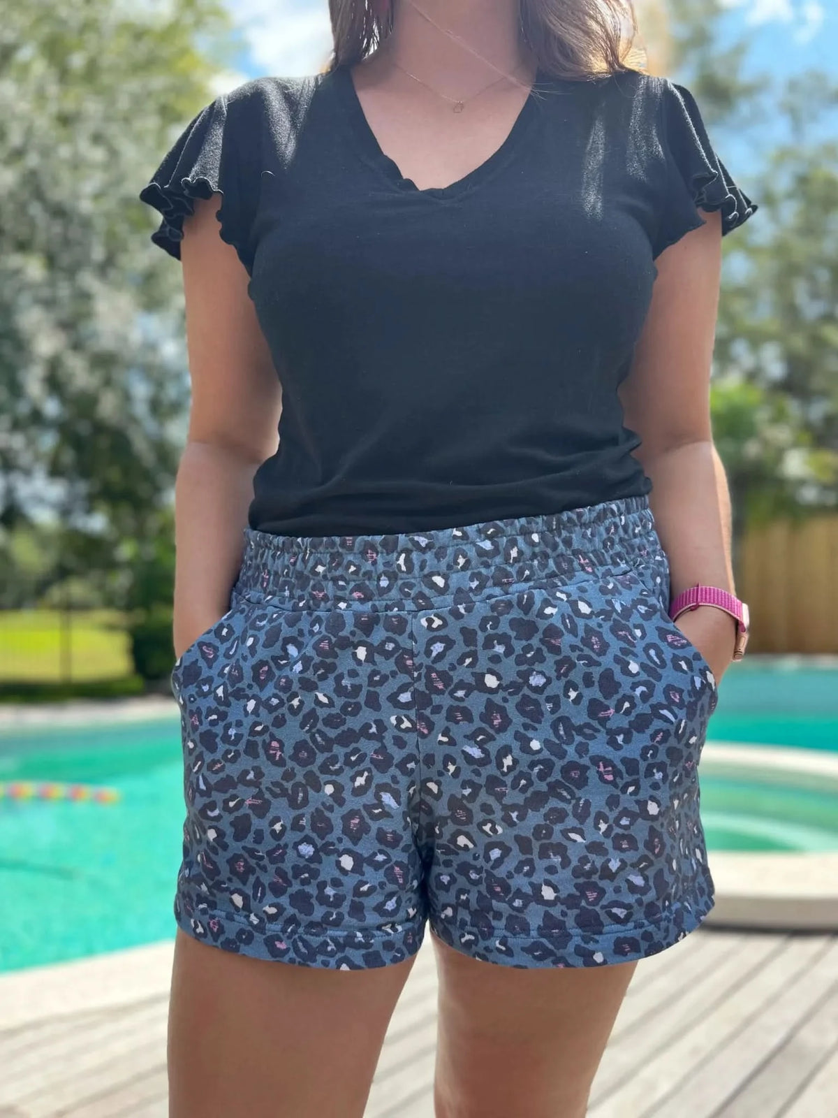 Teal leopard animal print fabric in summer design, shown as shorts with black top.