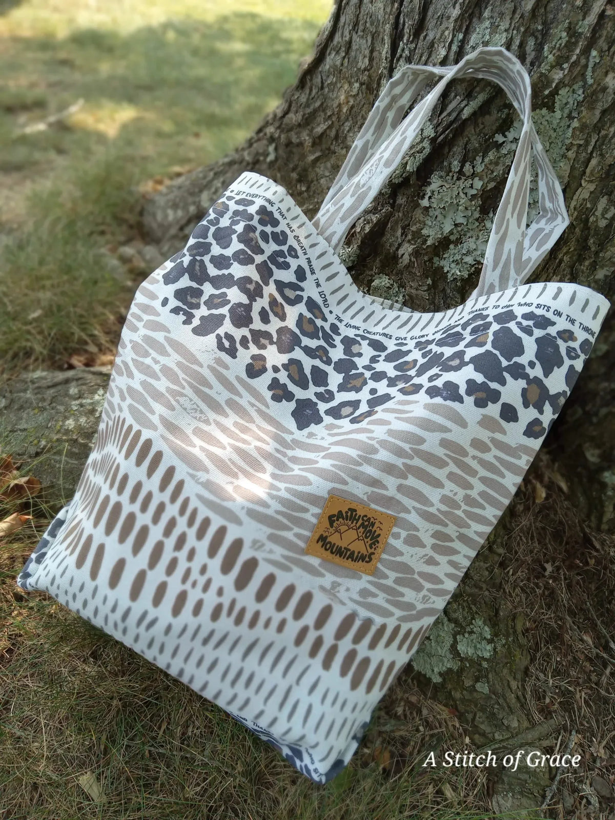 A tote bag with leopard print and a "Faith Can Move Mountains" patch.