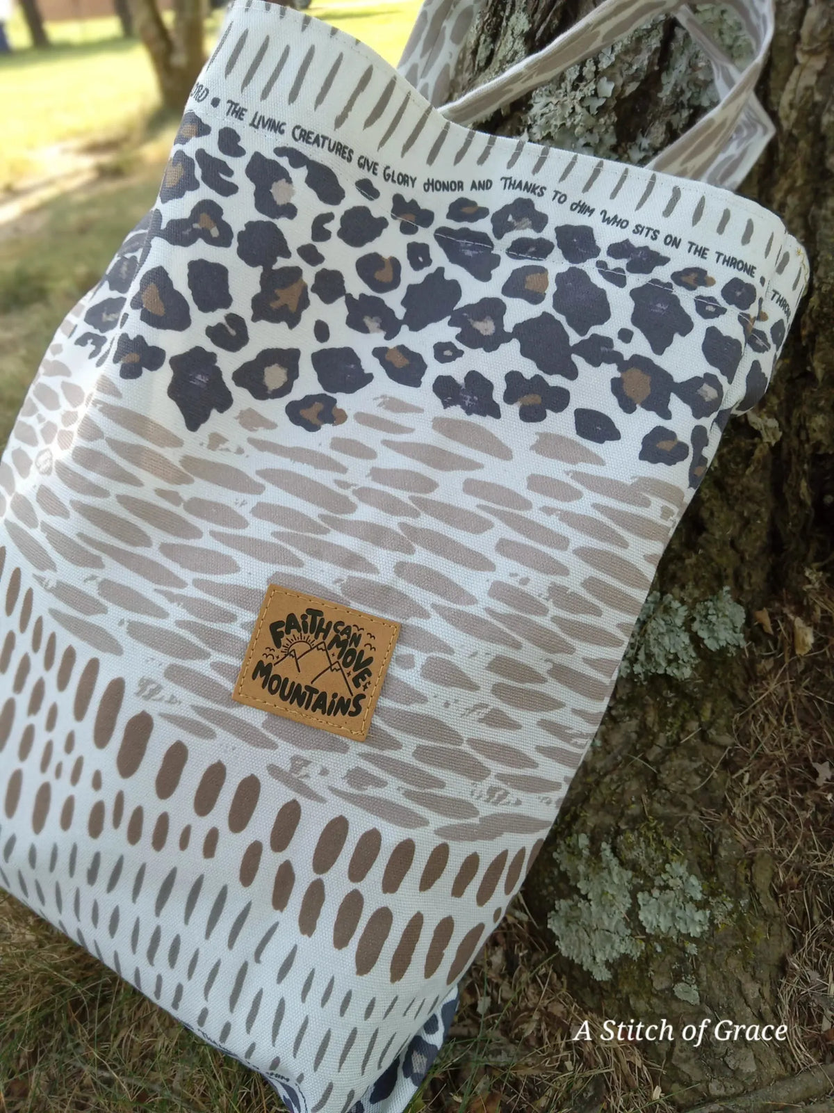 A tote bag with leopard print and a "Faith Can Move Mountains" patch.