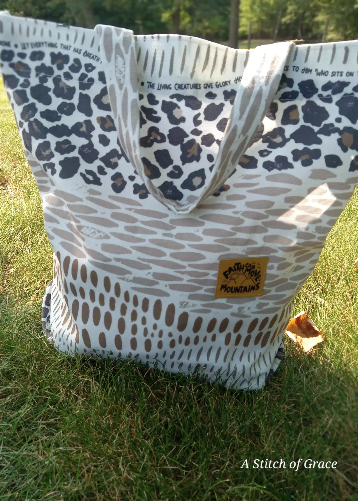 A tote bag with leopard print and text, "Faith Can Move Mountains" patch.