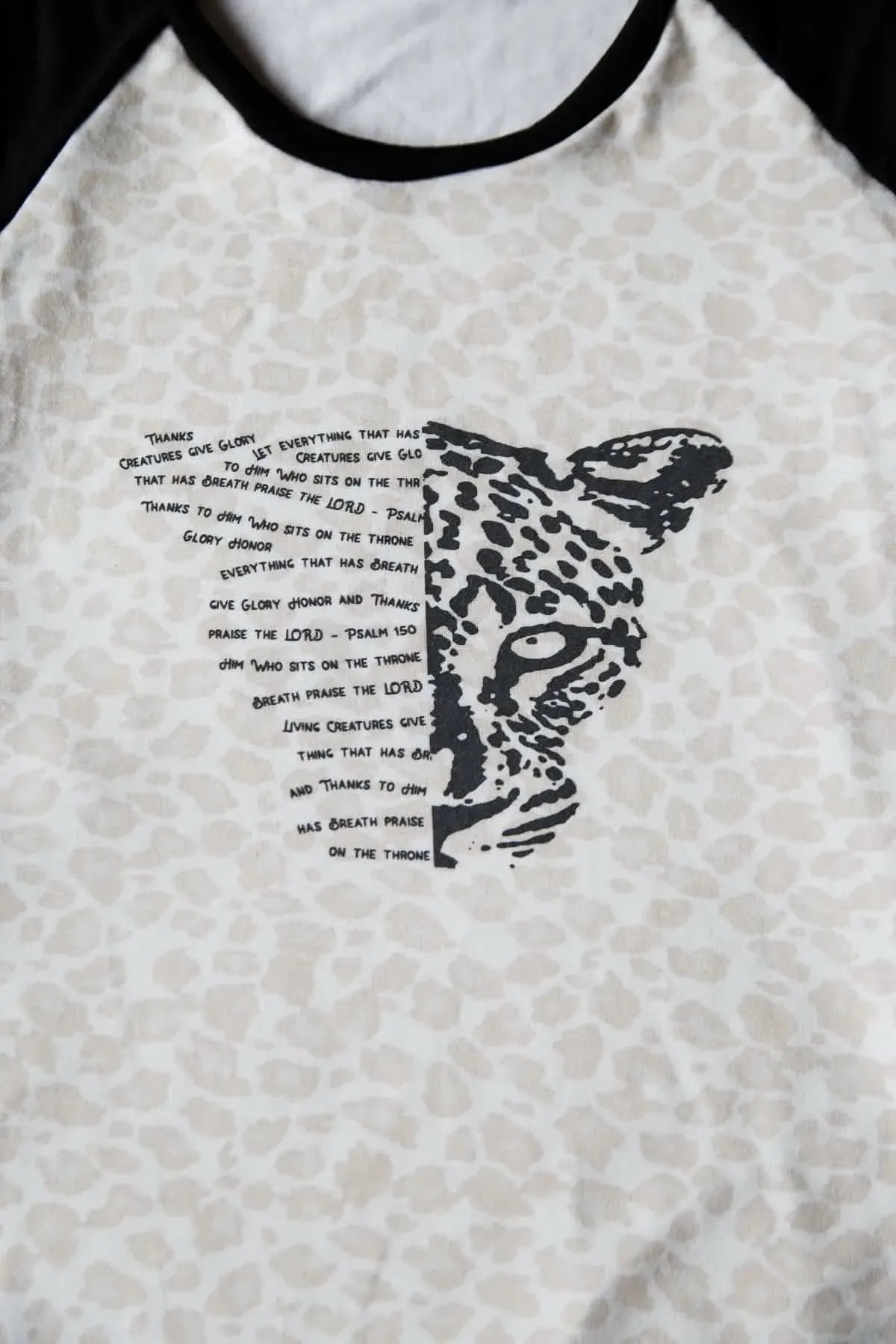 A white and black shirt with a leopard print and text.