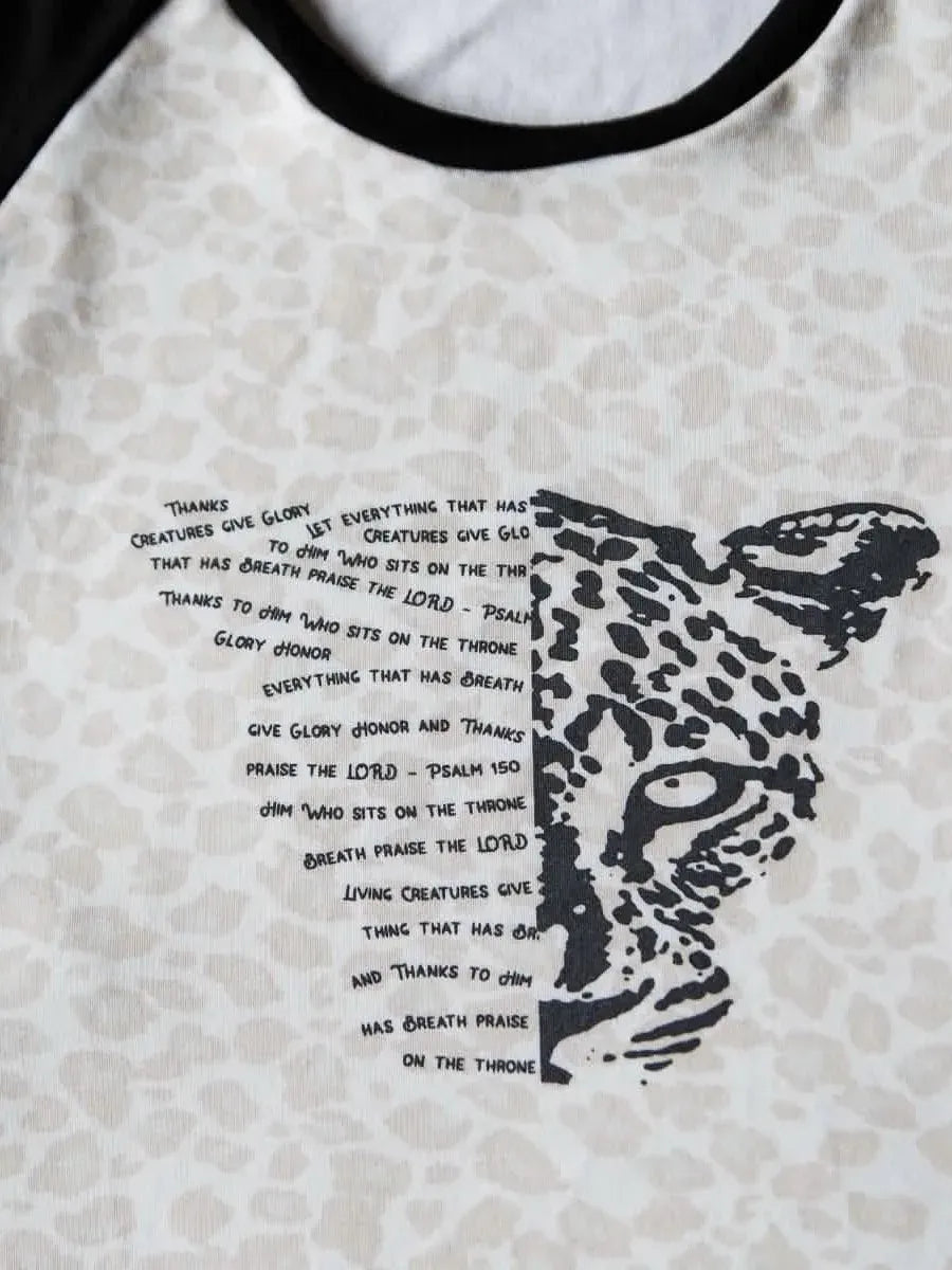 A white and black raglan shirt with a leopard print and text on the front.