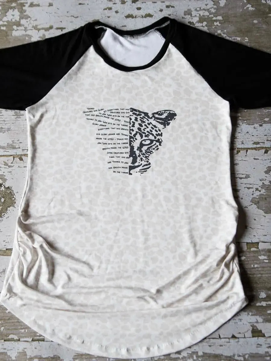 A raglan shirt with a leopard print body and black sleeves, featuring a leopard face.