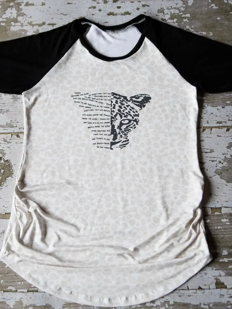 A raglan shirt with a leopard print body and black sleeves, featuring a leopard face.