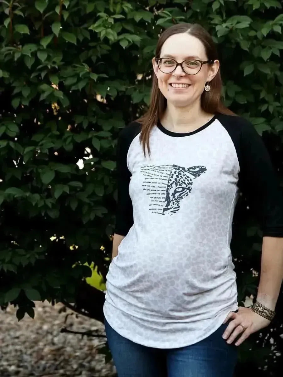 Woman modeling gray raglan T-shirt with black sleeves and creature print panel.