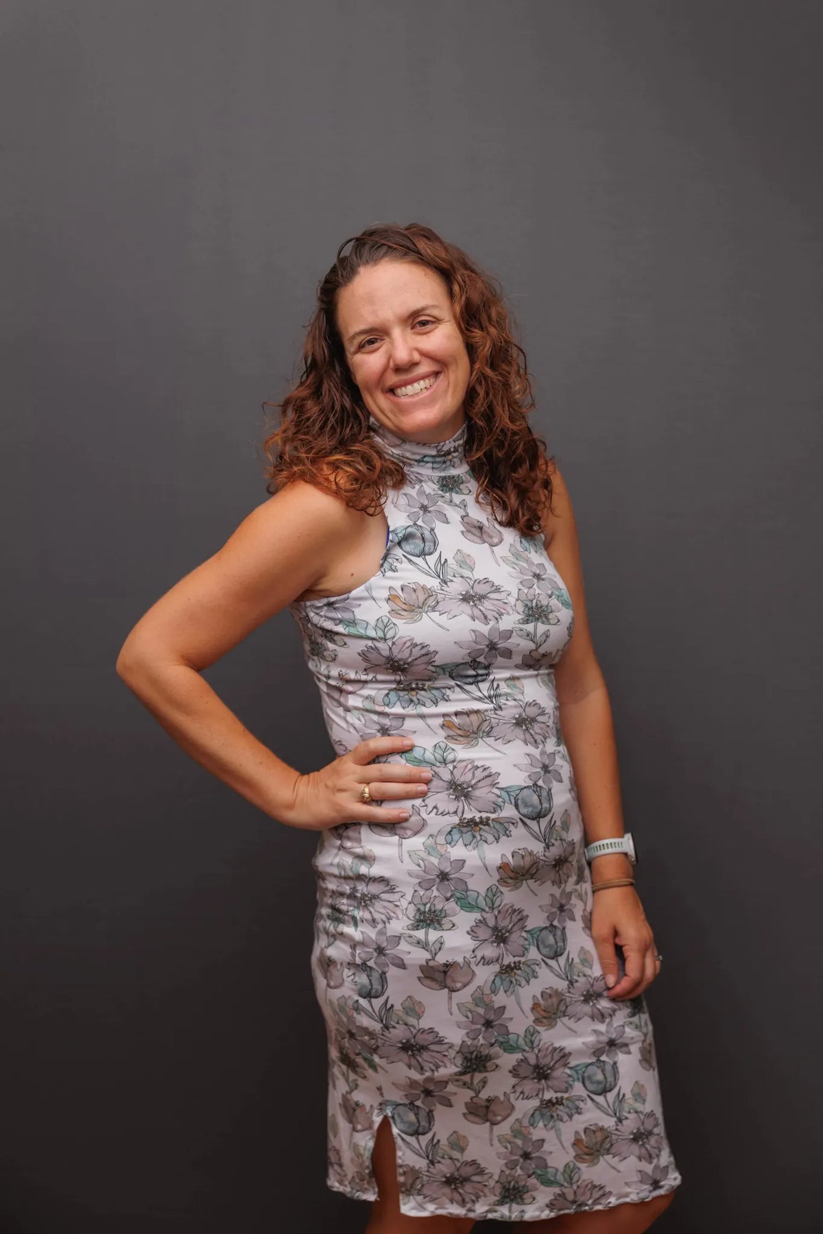 A woman in a floral dress smiles at the camera.