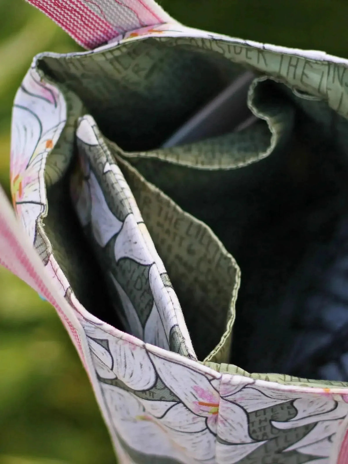 Close-up of a fabric bag with floral and text patterns.