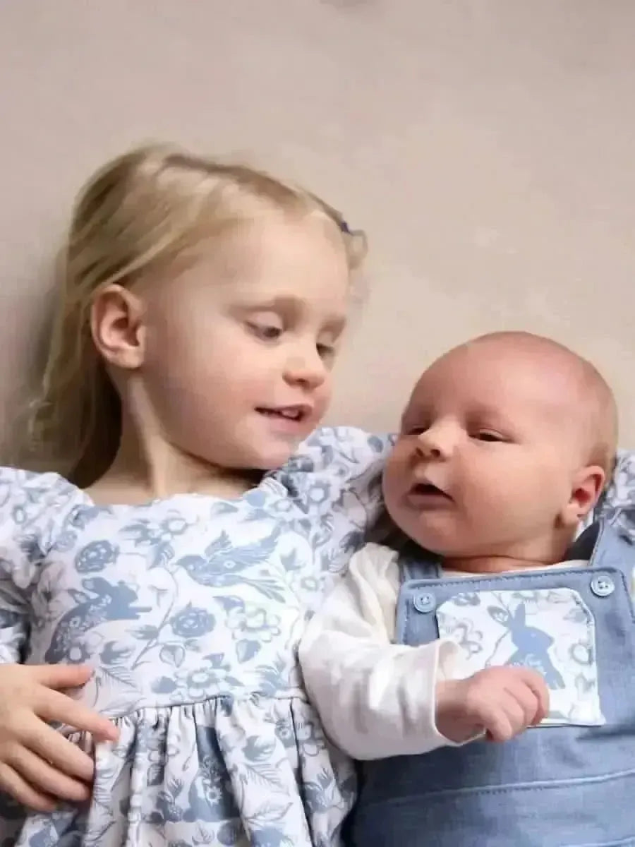 Blue linen fabric with botanical print in Carolina blue, featuring floral and bird motifs.