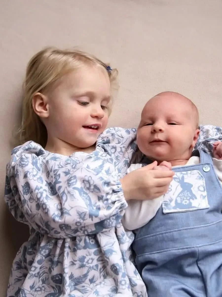 Two children lie on a Carolina Blue Linen fabric.