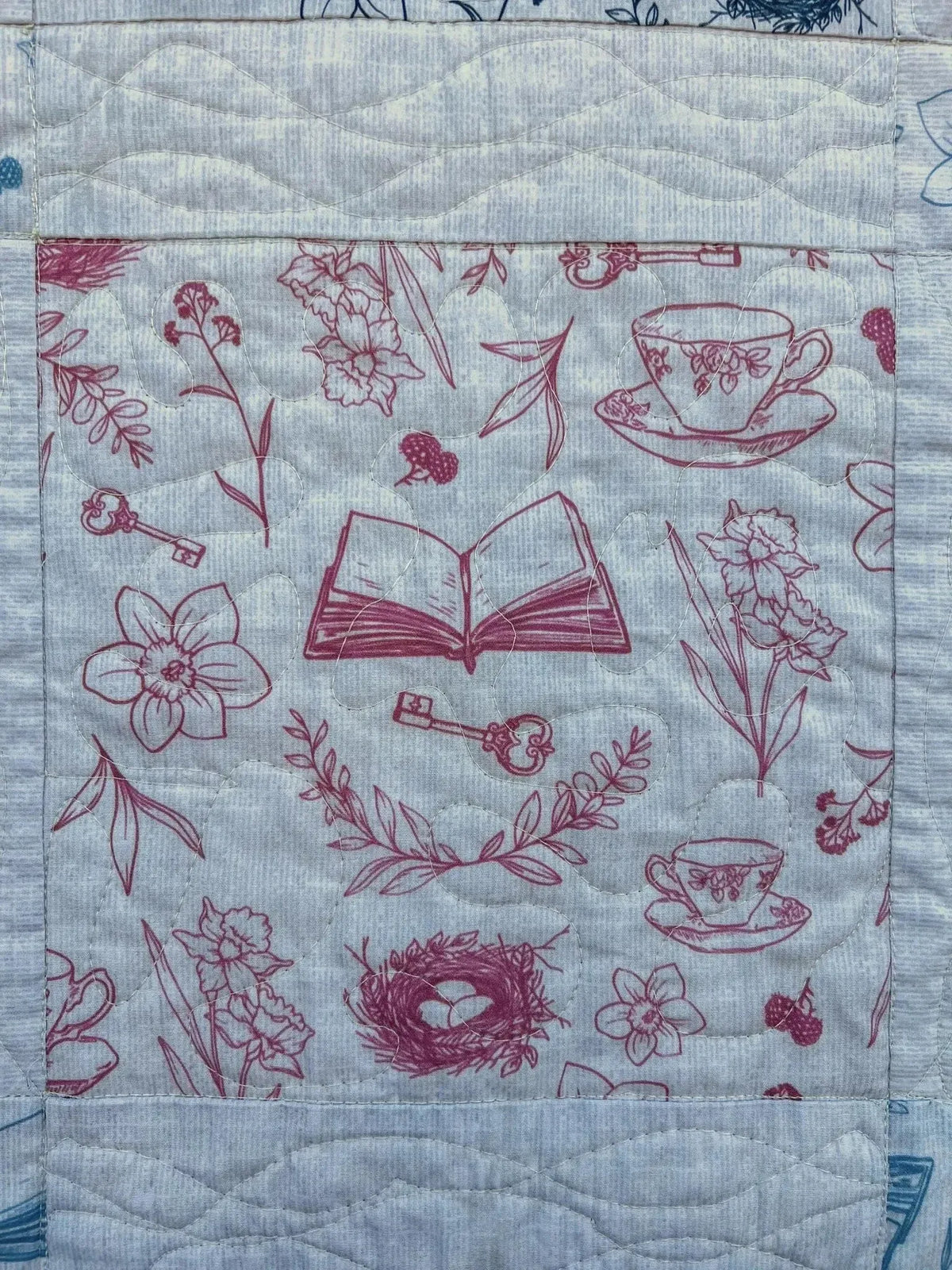 Red tea and toile faith-based print fabric with flowers, books, teacups, and keys.