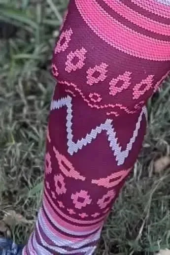 Pink abstract fabric with geometric patterns in pink and maroon tones.