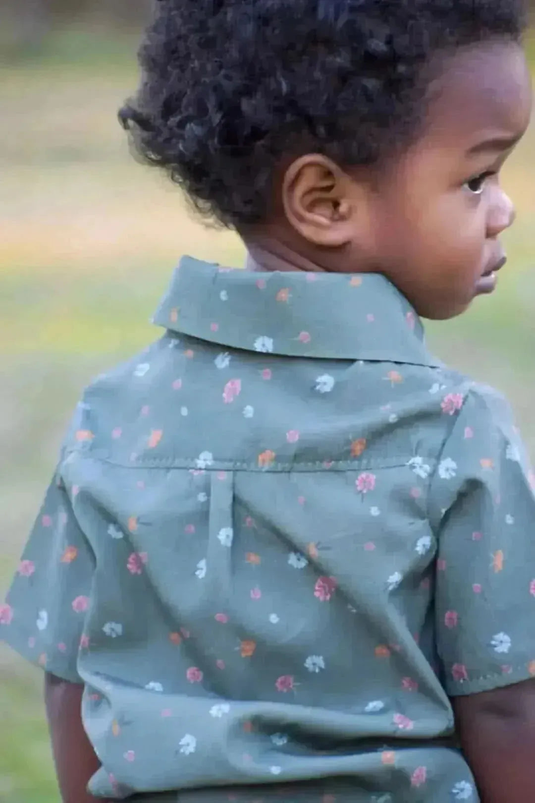 Olive ditsy floral fabric with small blooms on a green background.