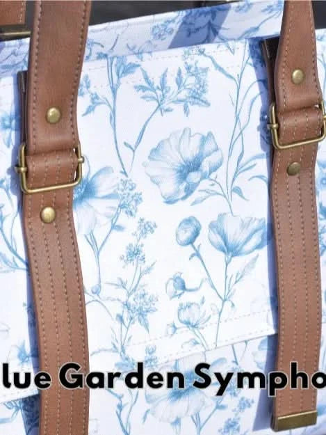 A white canvas fabric with a blue floral pattern and brown straps.