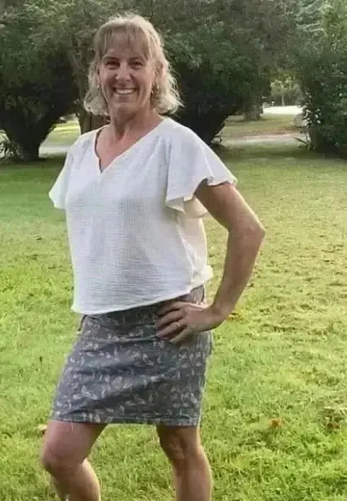 Blush hollow floral print fabric in a sewn skirt and top on a model outdoors.