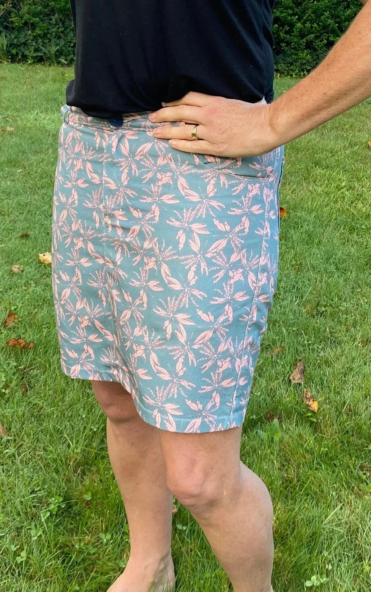 Blush hollow floral print fabric with pink and white leaf motifs on a teal background.