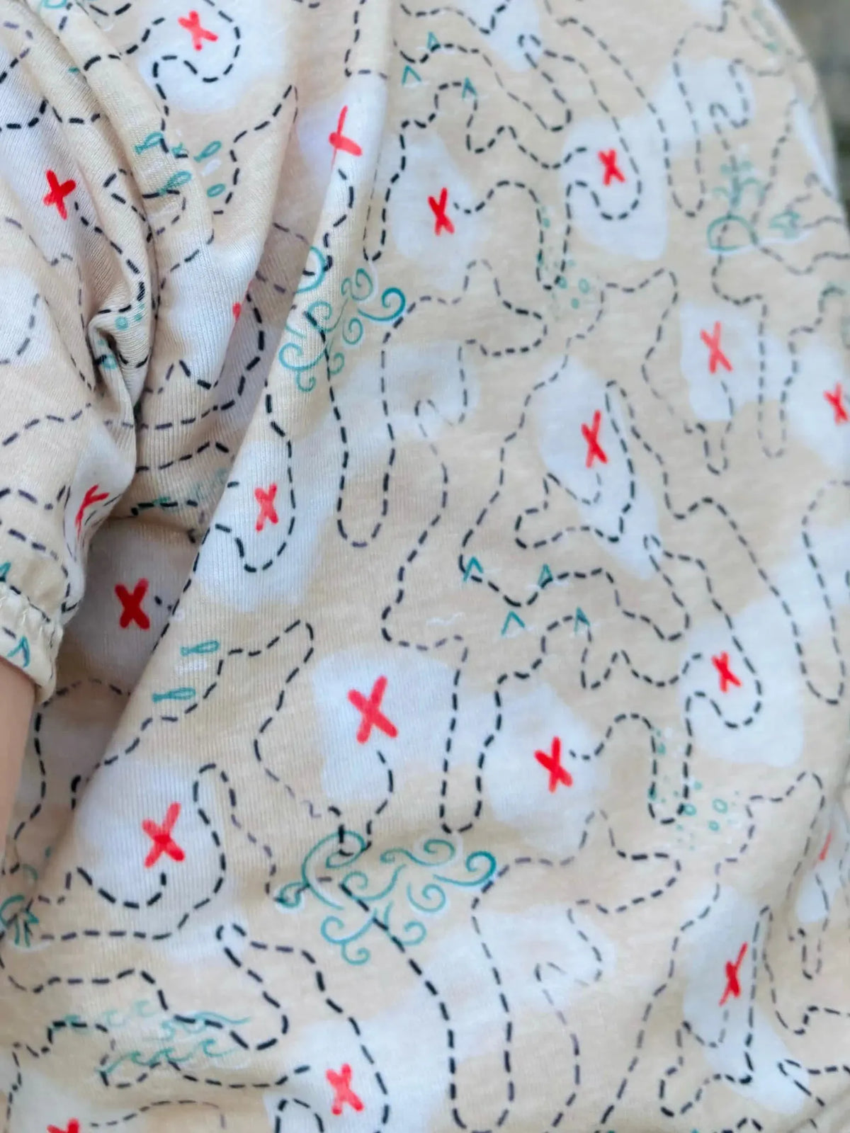 Fabric with a buried treasure map pattern, featuring red X marks and dashed lines.
