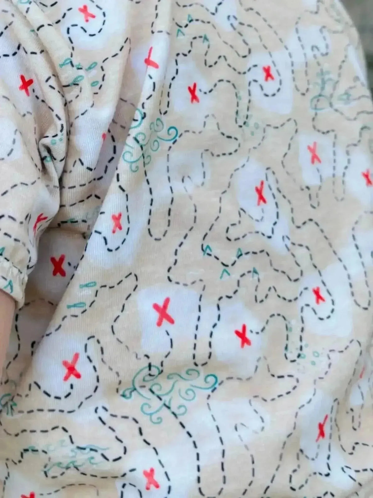 Beige fabric printed with pirate treasure map lines, red X marks, and teal swirls.
