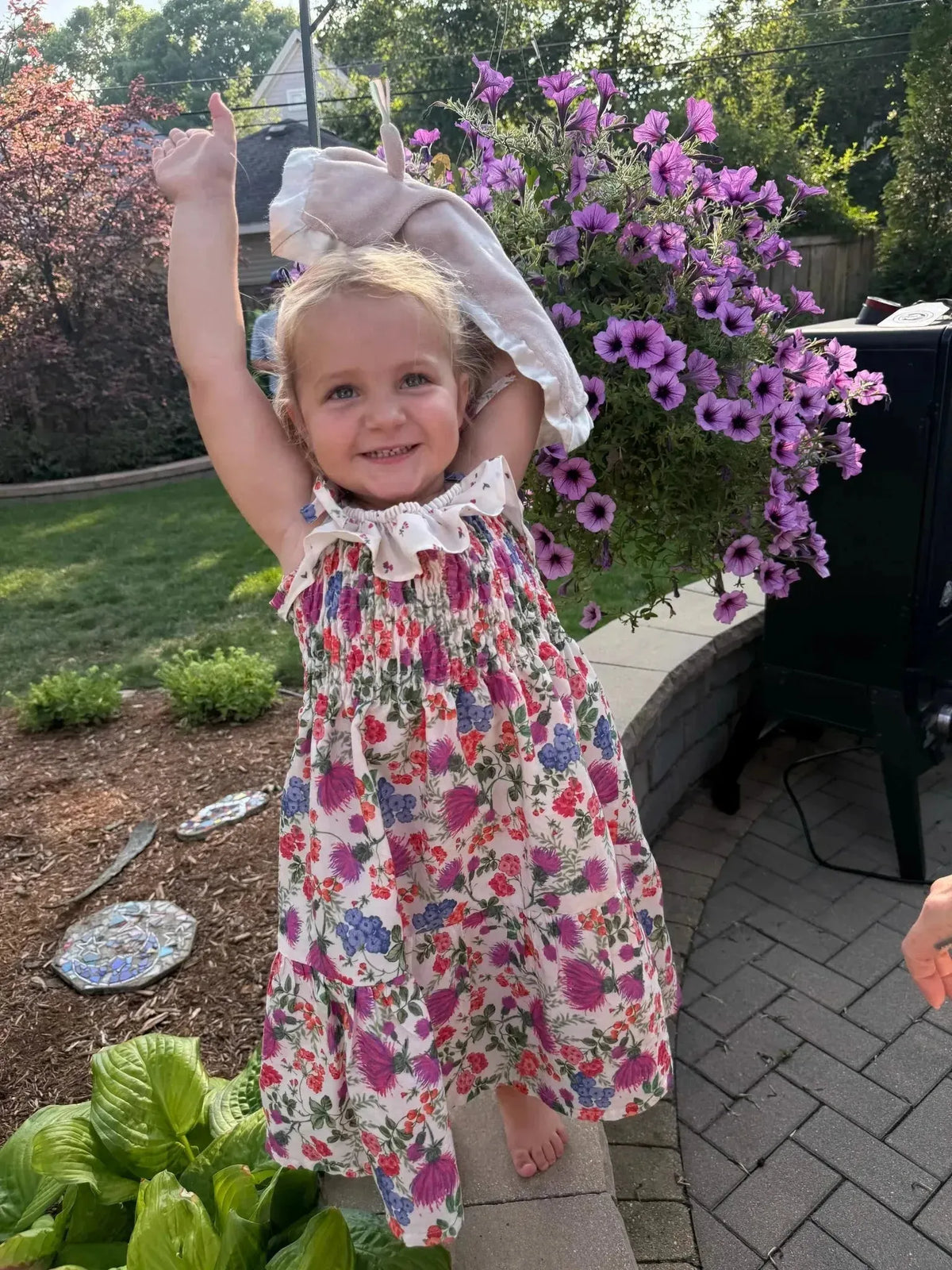 Floral print fabric with thistle field pattern in purple, pink, and white on cream background.