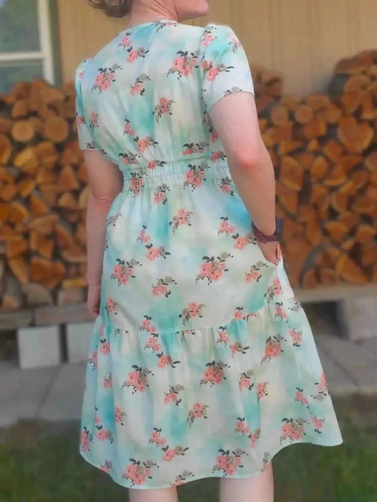 Light blue fabric with floating pink peony floral print, shown as a back-view dress.