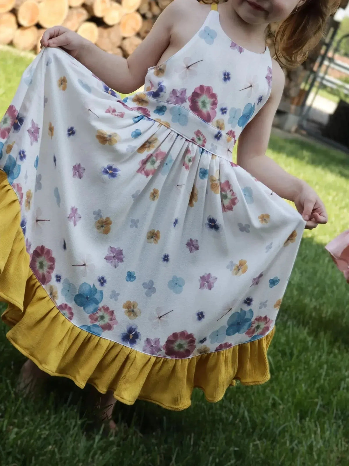 White fabric with hand-pressed pastel floral blooms in pink, blue, and yellow.