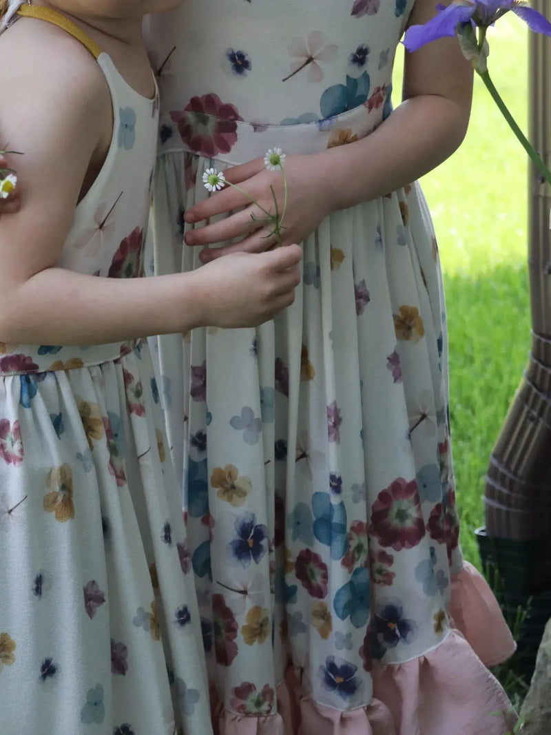 Hand-pressed pastel floral print fabric with blooms and dragonflies on white base.